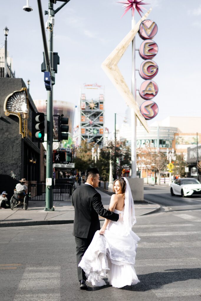 Bride and groom walking down Fremont Street after their a Little White Chapel Vegas elopement
