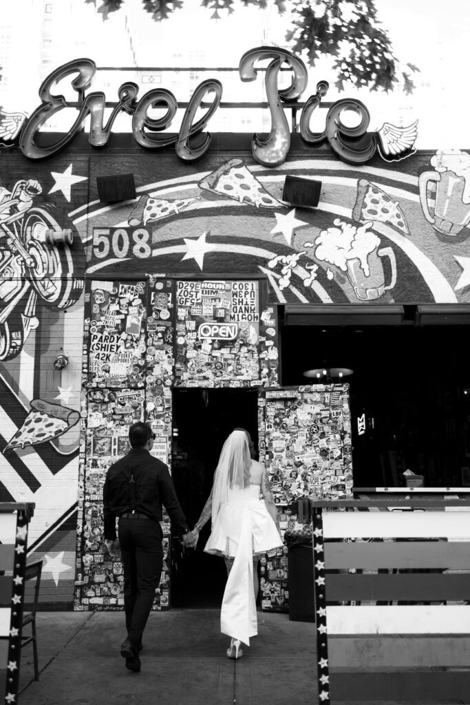 Bride and groom walking into Evel Pizza