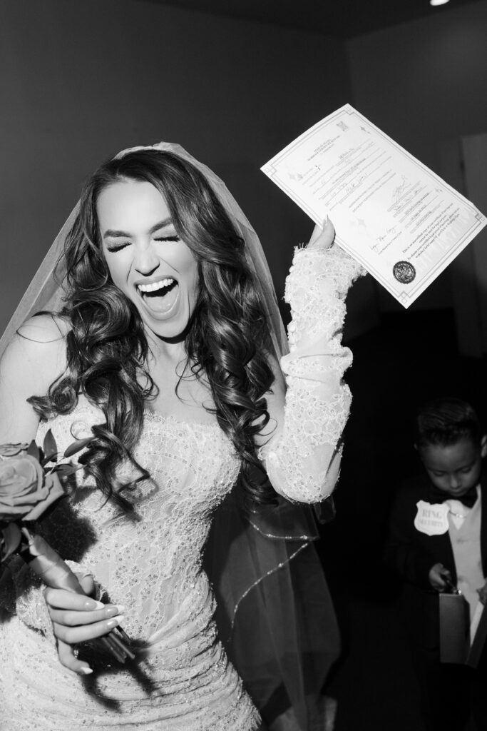 Bride holding up her marriage license in the air after her Las Vegas elopement.