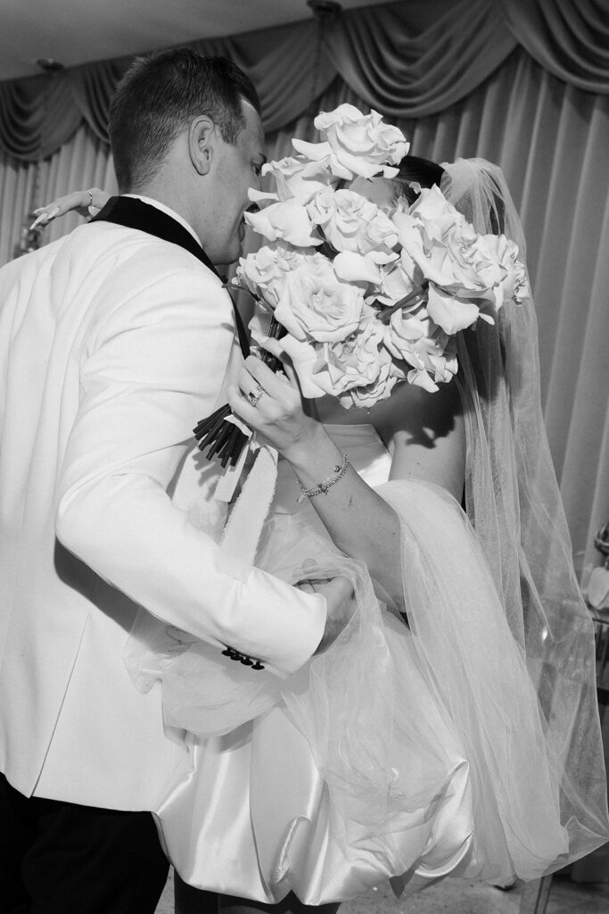 Black and white photo of a bride and groom kissing behind a veil for their Las Vegas elopement photos. 
