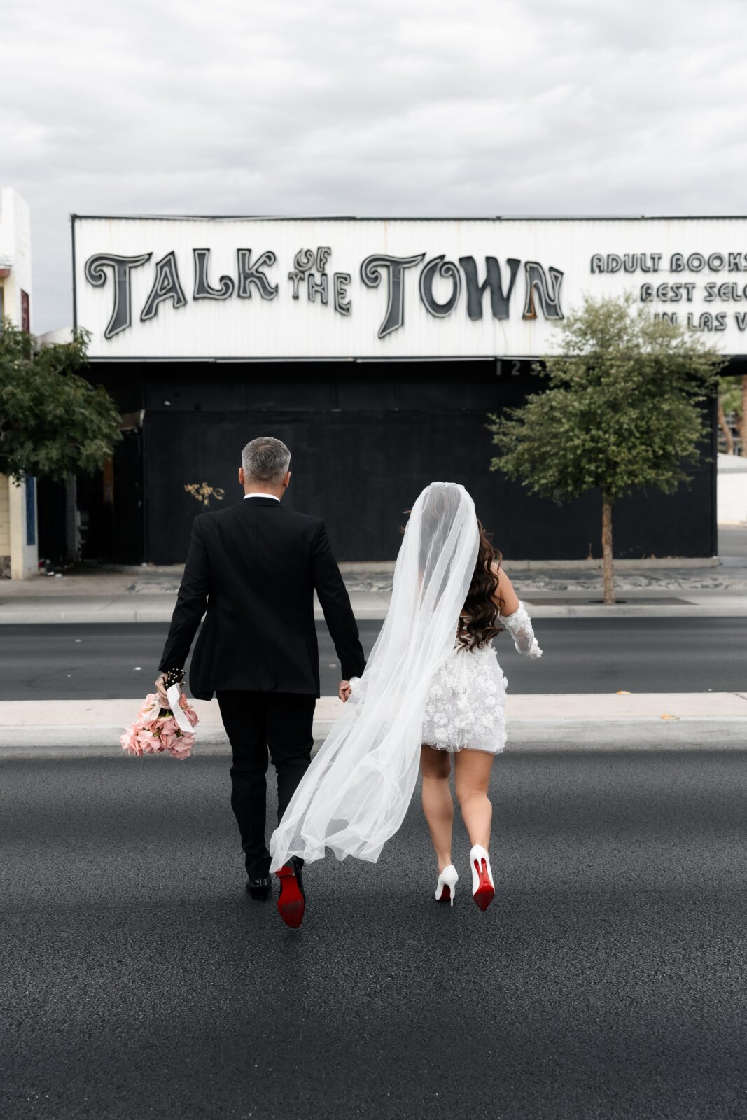 Couple walking across the street in front of Talk of The Town in Las Vegas. 