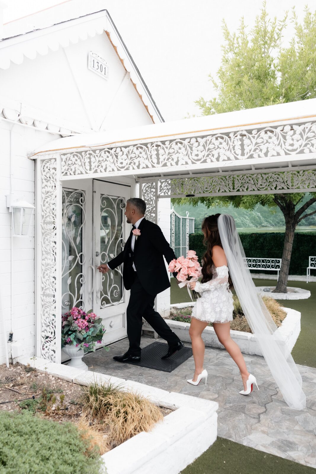 Bride and groom walking into Little White Wedding Chapel for their elopement. 
