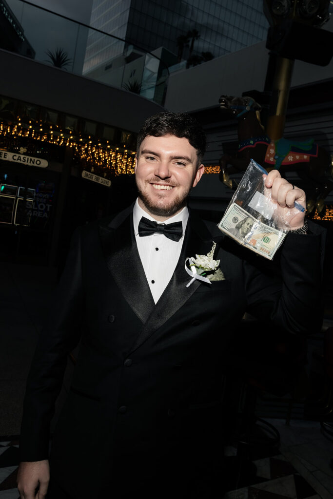 Groom holding up a bag of money in Las Vegas.