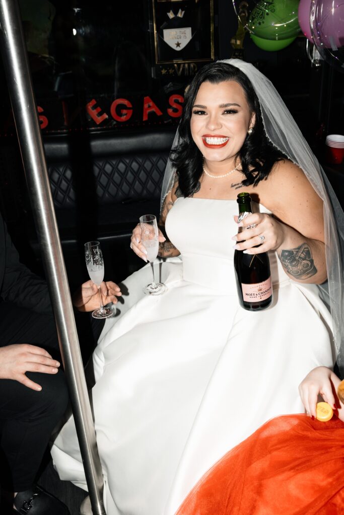 Bride drinking champagne on the party bus