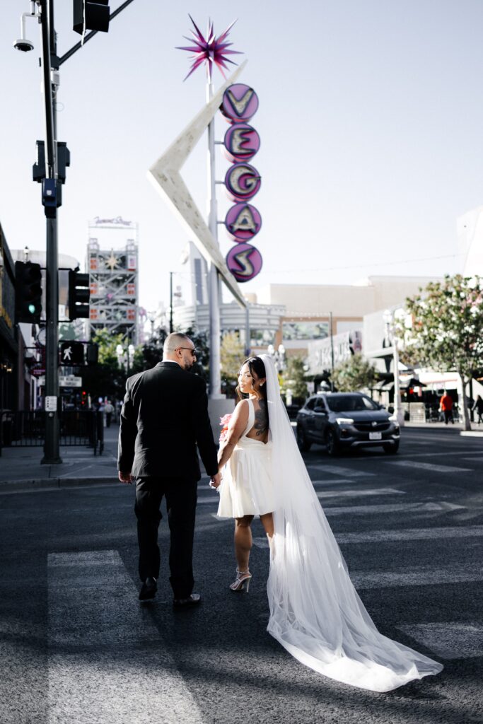 Bride and groom walking down Fremont Street in Las Vegas