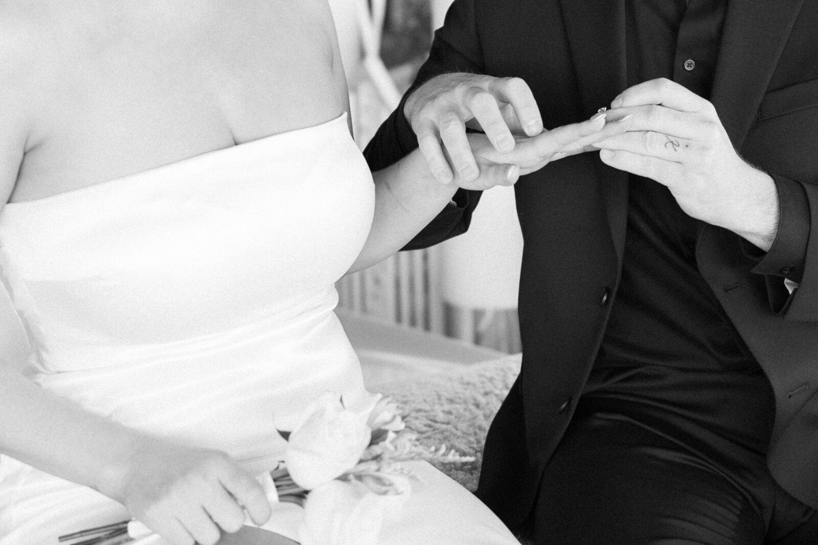 Groom putting ring on his brides finger
