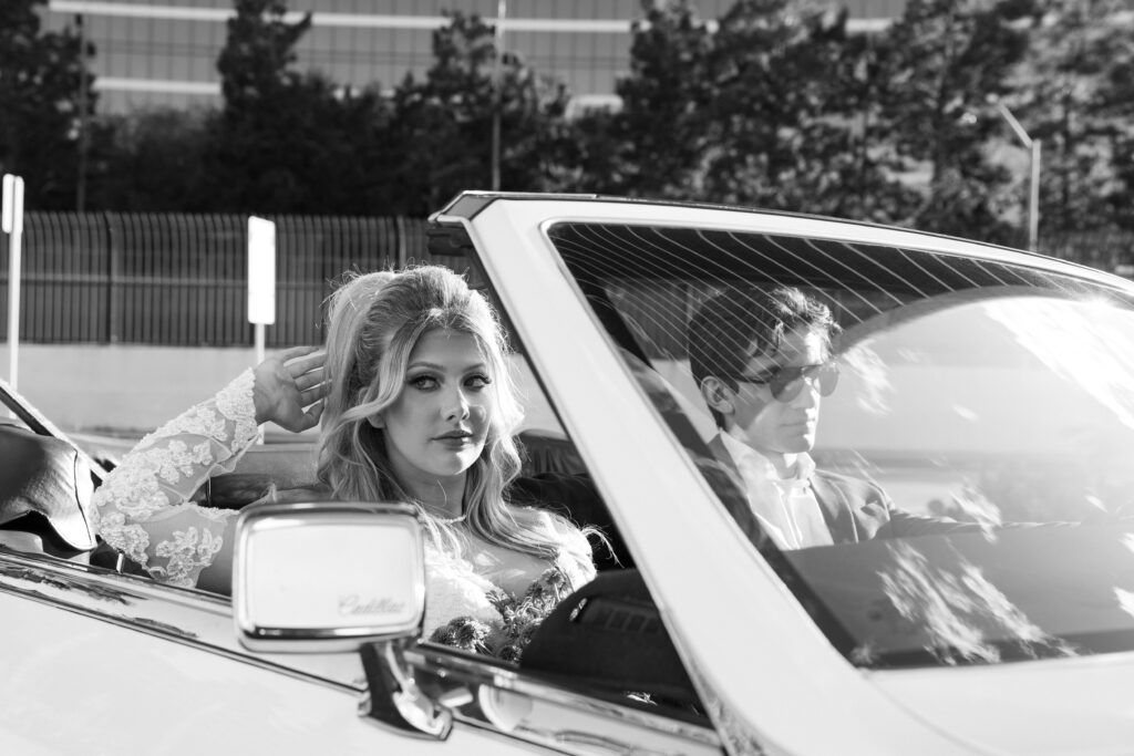 Bride and groom riding in a vintage car