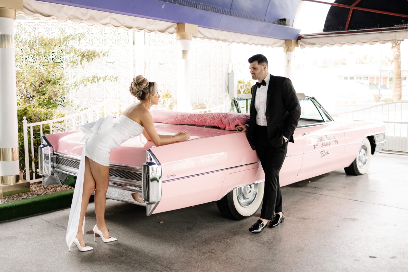 Bride leaning against the Pink Cadillac at The Little White Chapel during their elopement in Vegas