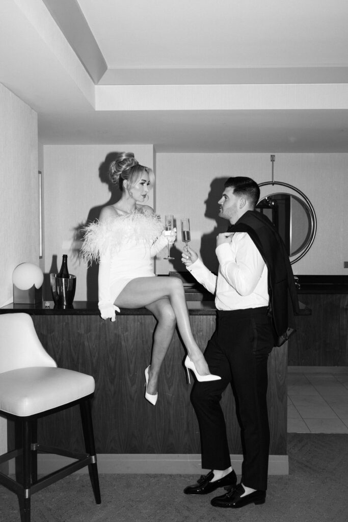 Black and white photo of a bride and groom toasting their champagne during their elopement in Vegas