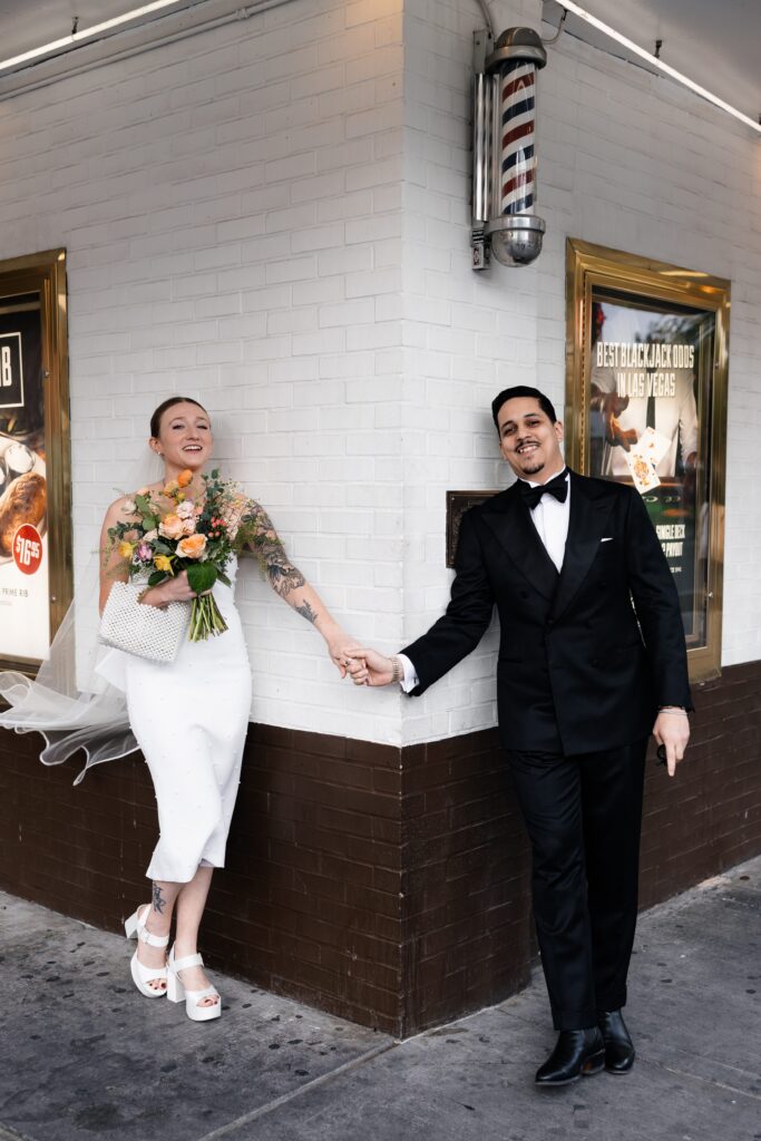 Bride and groom holding hands about to share their first looks at the corner of El Cortez Hotel and Fremont Street in Las Vegas