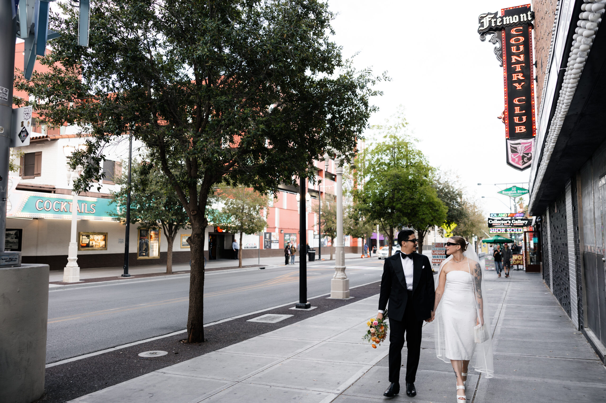 Bride and groom walking down Fremont Street together for their Las Vegas wedding elopement portraits