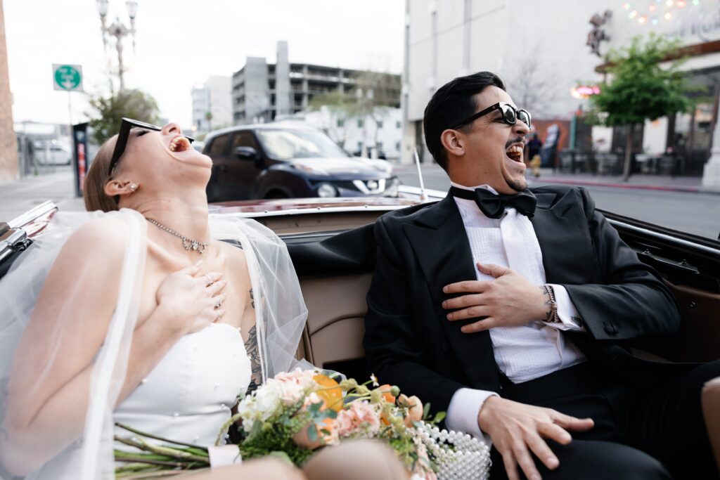 Bride and groom laughing in a classic car during their Las Vegas elopement wedding