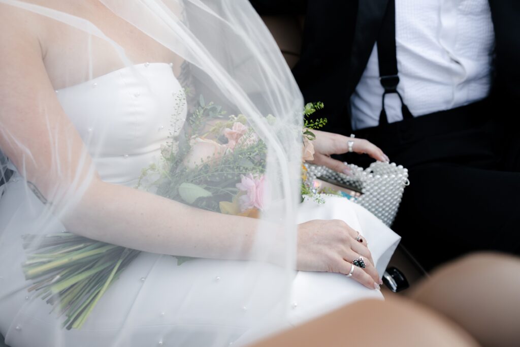 Close up detail shot of a bride and groom sitting next together in a car