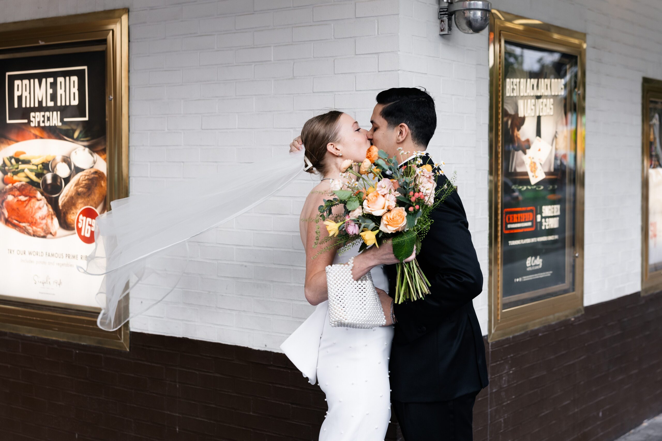 Bride and groom kissing after their first looks at the corner of El Cortez Hotel and Fremont Street in Las Vegas