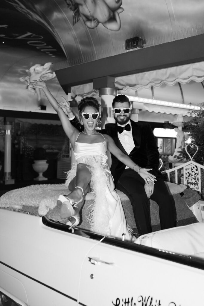 Black and white bride and groom flash portraits with the Pink Cadillac in The Tunnel of Love in Las Vegas