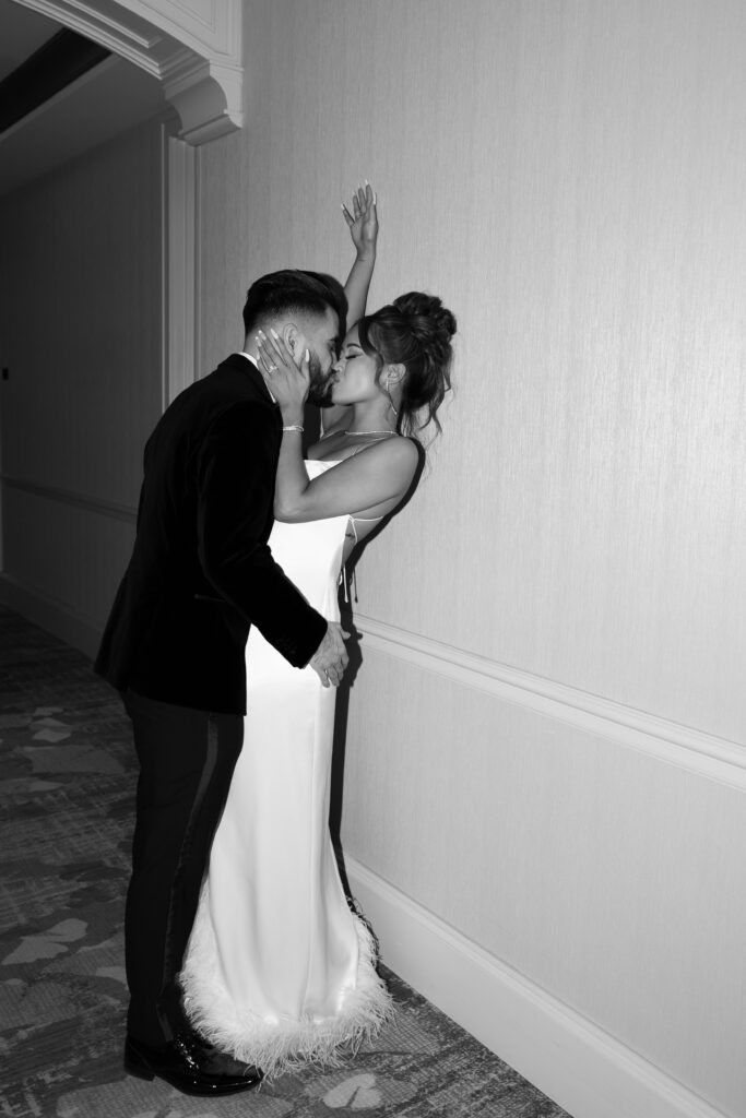 Black and white photo of bride and groom kissing in the hallway at Palazzo Hotel in Las Vegas
