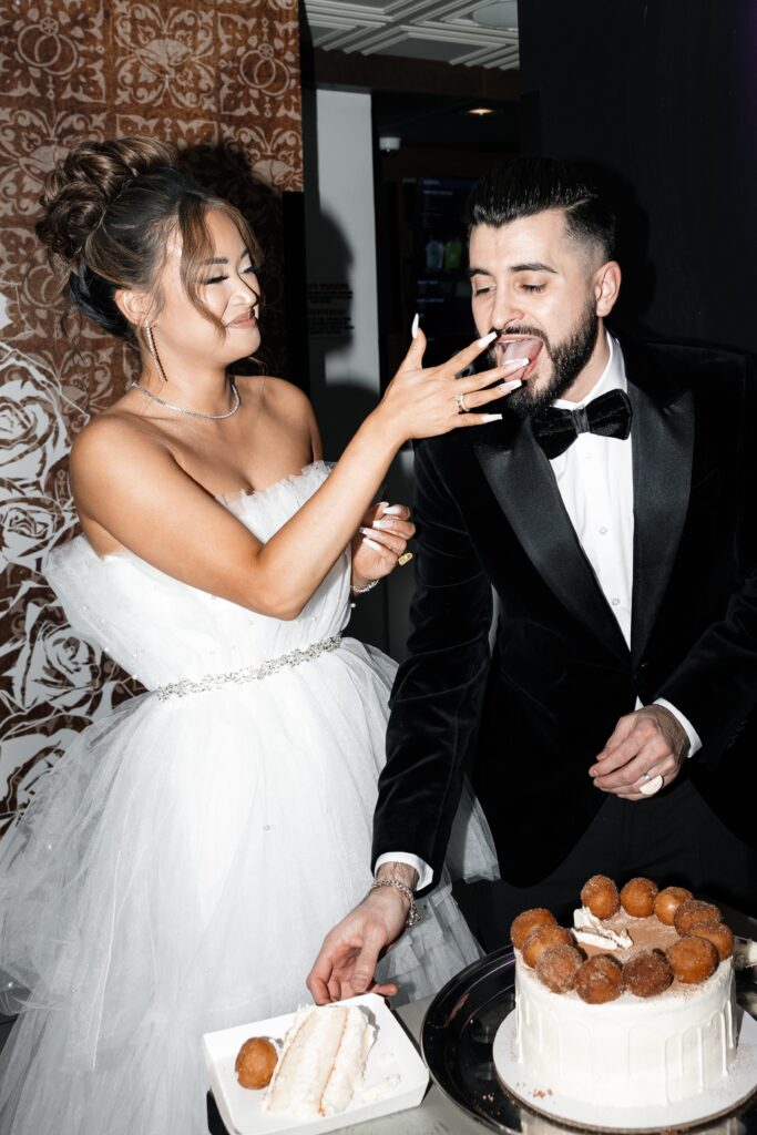 Bride and groom eating their Cinnabon delights cake during their Taco Bell Las Vegas wedding