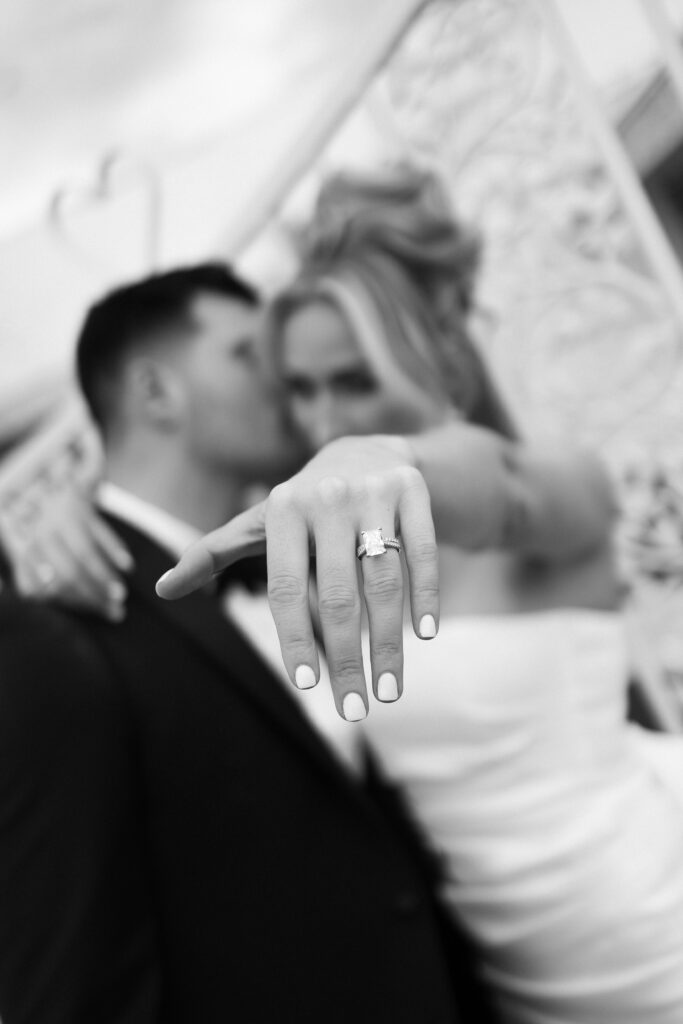 Black and white photo of a bride and groom showing off their rings after they eloped in Las Vegas