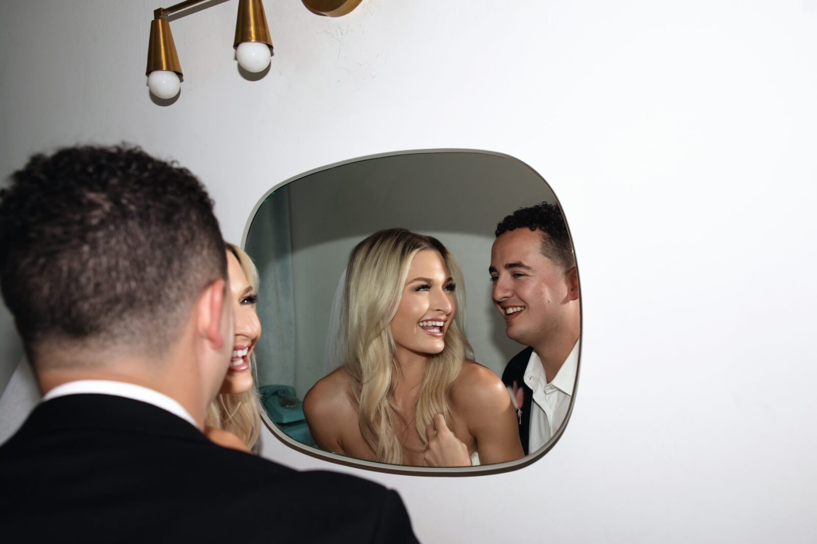 Bride and grooms portraits in the bathroom mirror at Sure Thing Chapel in Las Vegas