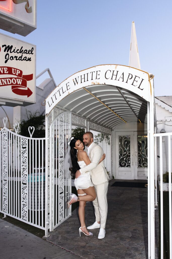 Bride and grooms editorial elopement photos in front of Little White Wedding Chapel