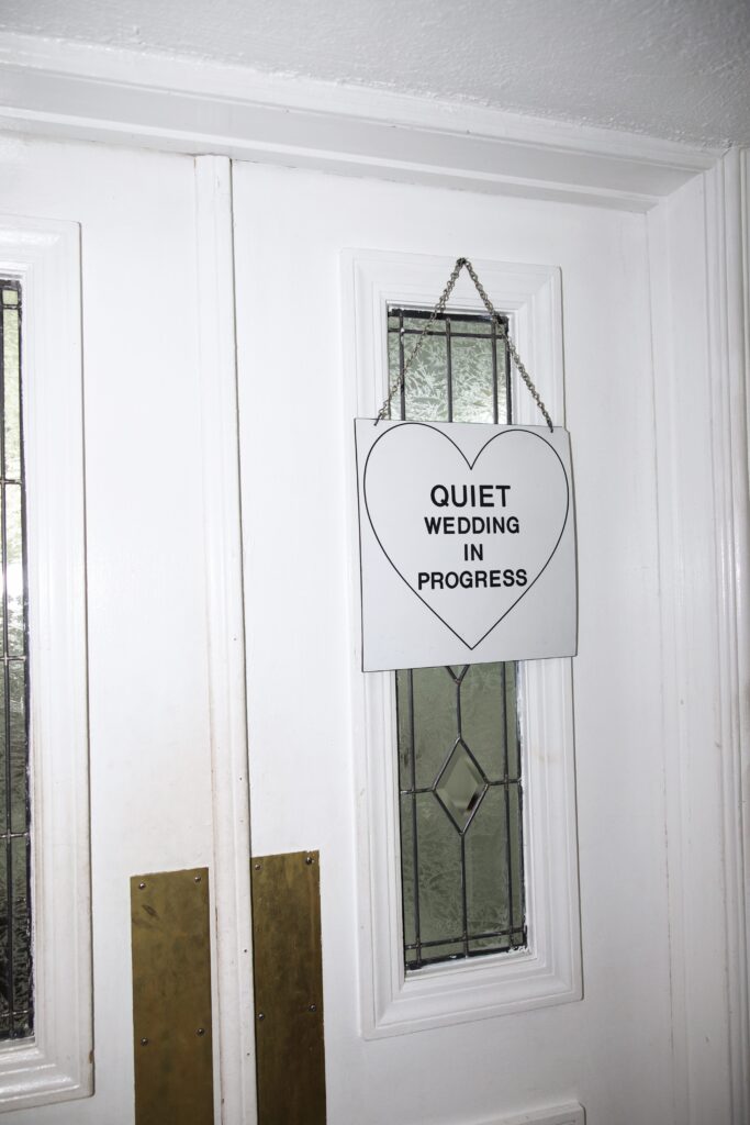 Sign hanging on Little White Wedding Chapel door that says "Quiet, wedding in progress"
