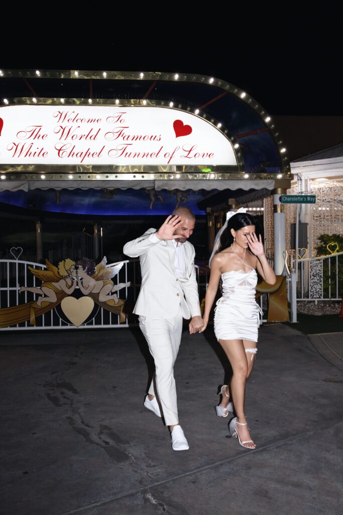 Bride and groom covering their faces for paparazzi shots during their Little White Wedding Chapel elopement in Las Vegas