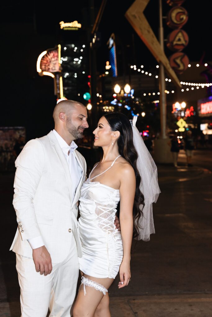 Bride and groom smiling at each other as they pose for their Las Vegas elopement portraits