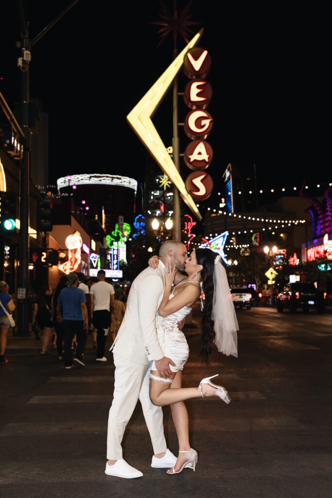 Bride and groom kissing in front of the famous Vegas neon sign on Fremont Street