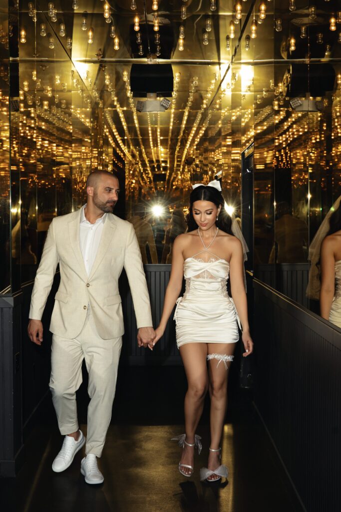 Bride and groom walking down a hallway with overhead lights in Las Vegas