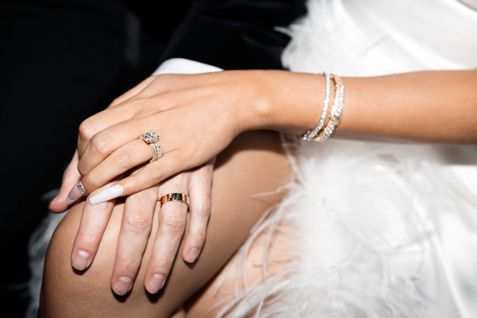 Close up shot of a bride and groom holdings hands with their wedding rings on