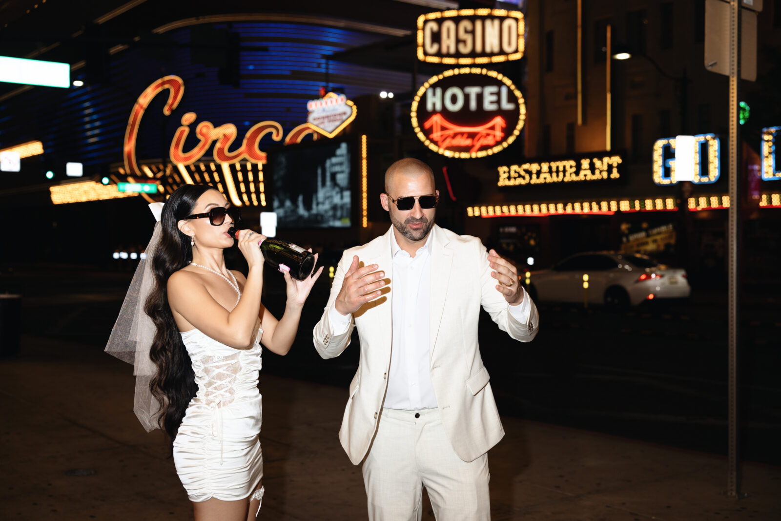 Bride and groom drinking champagne on Fremont Street in Las Vegas