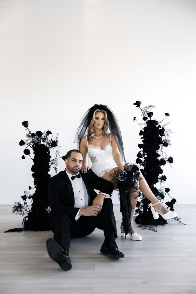 Bride and groom posing with black wedding florals by Night Garden Floral - Las Vegas Wedding Florist