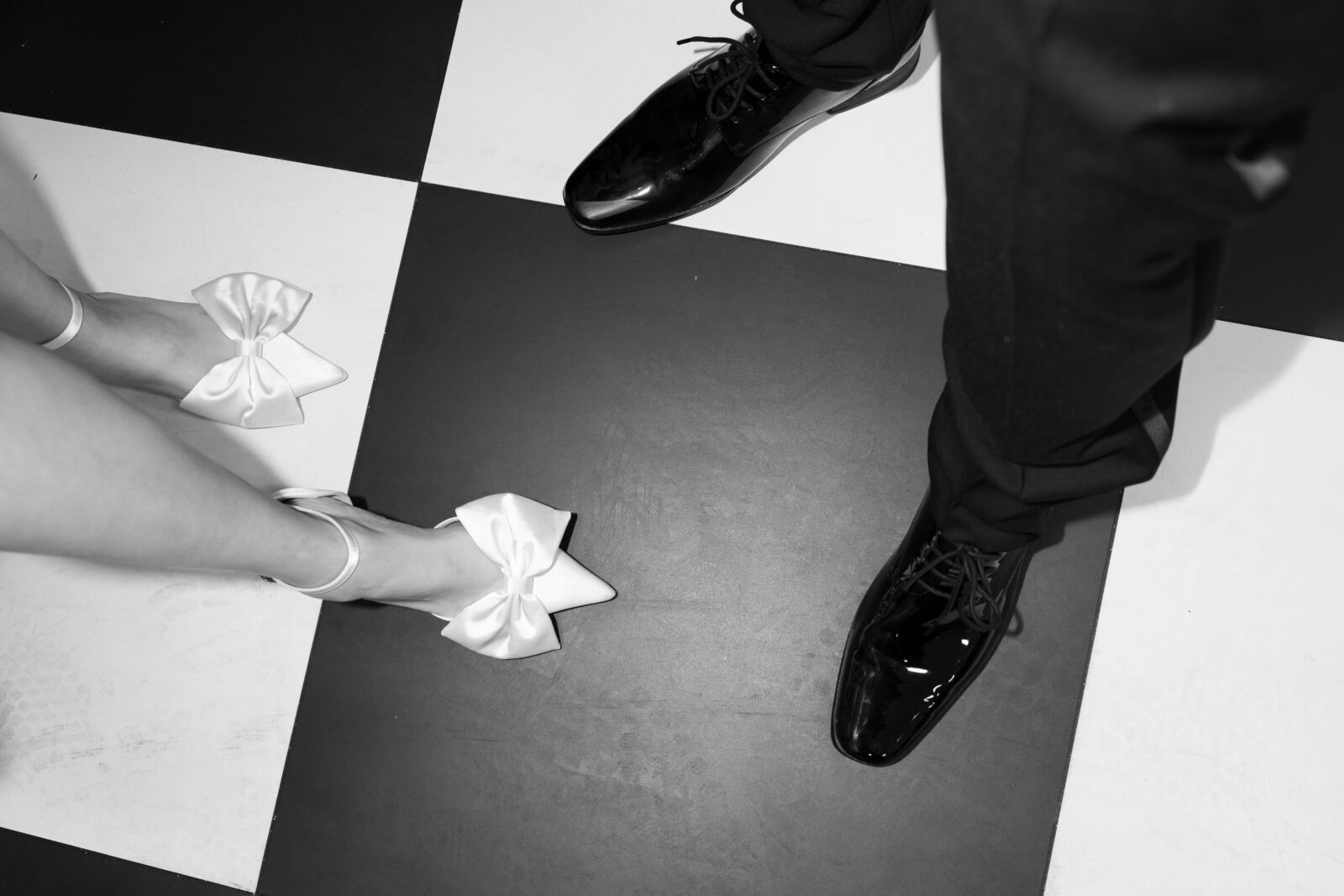 Black and white photo of a bride and grooms shoes