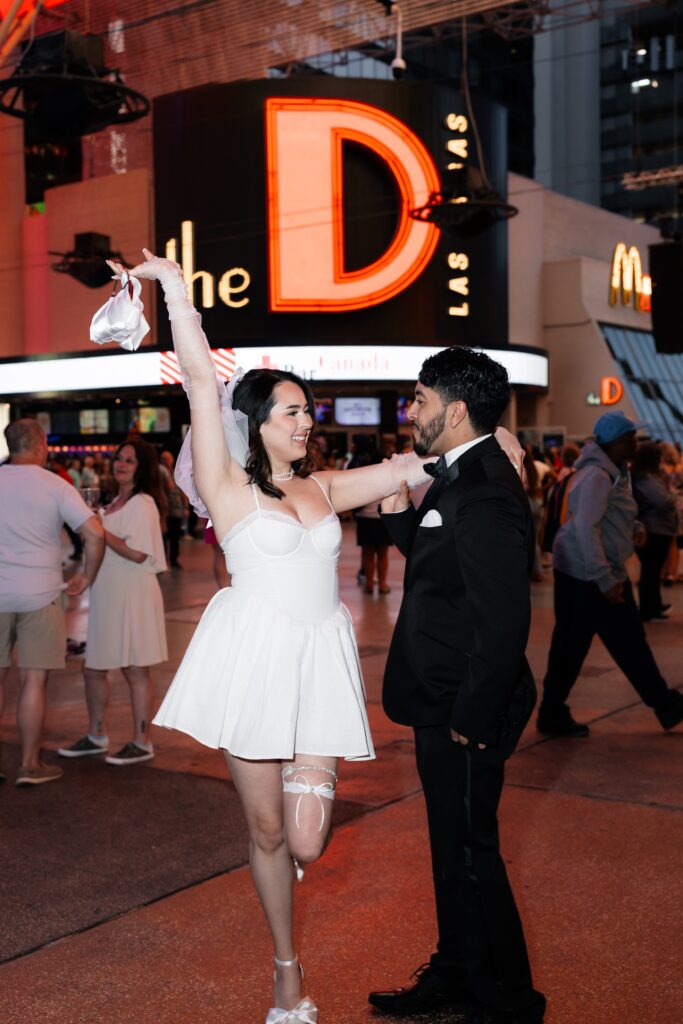 Bride and groom posing in front of the D Hotel & Casino during their fun elopement in Vegas