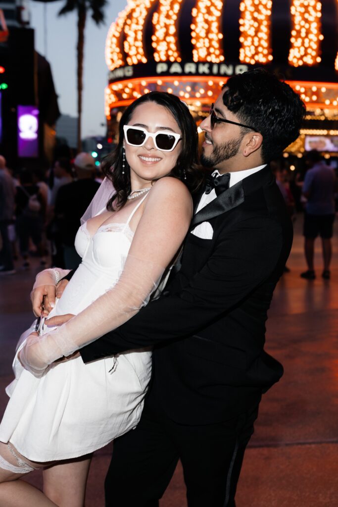 Bride and groom posing in front of the D Hotel & Casino during their fun elopement in Vegas