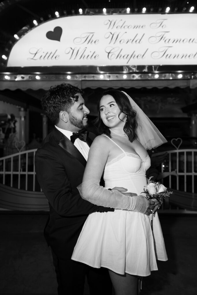 Black and white elopement photo of a bride and groom posing at The Little White Wedding Chapel