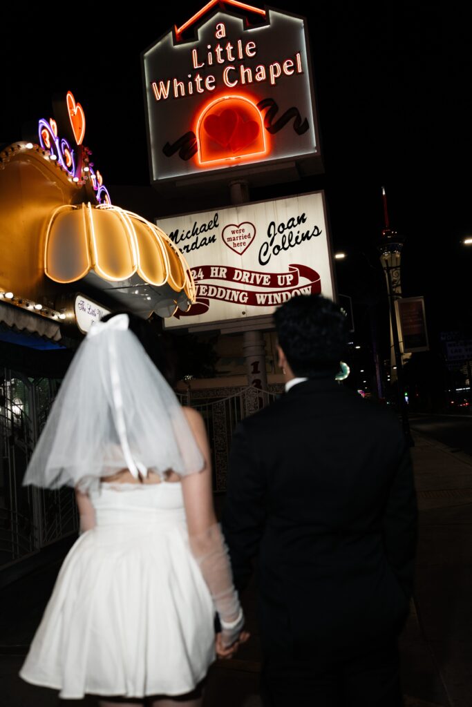 Bride and grooms flash elopement photos at night at The Little White Wedding Chapel