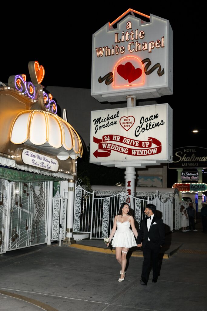 Bride and grooms flash elopement photos at night at The Little White Wedding Chapel