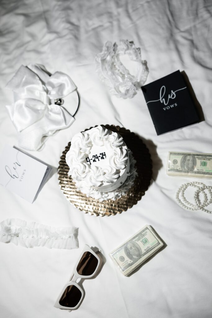 Las Vegas elopement detail shot with cake, vow books, cash, and accesories. 