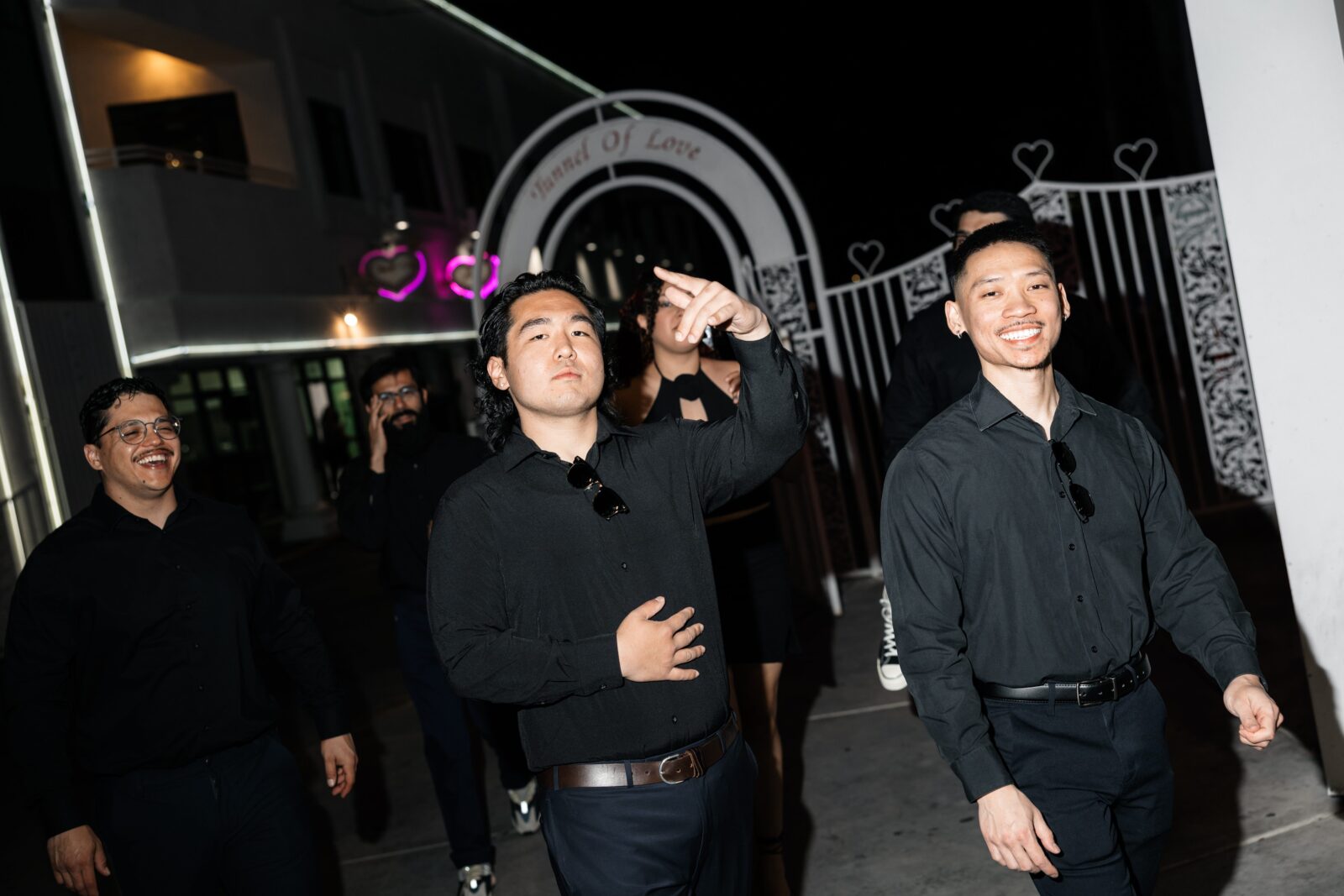 Groomsmen laughing while walking into The Little White Wedding Chapel