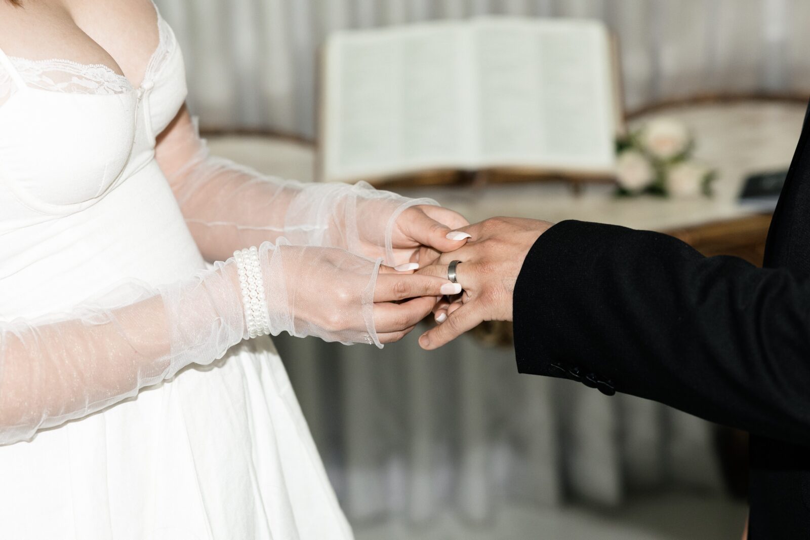 Bride putting the ring on her grooms finger