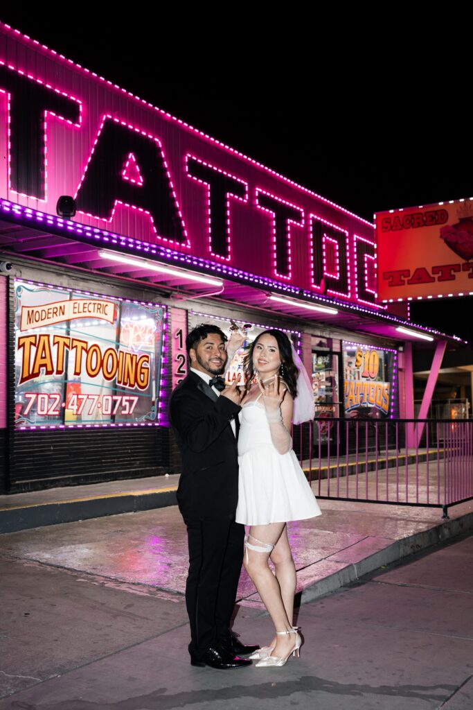 Bride and groom posing in front of Modern Electric Tattooing in downtown Las Vegas