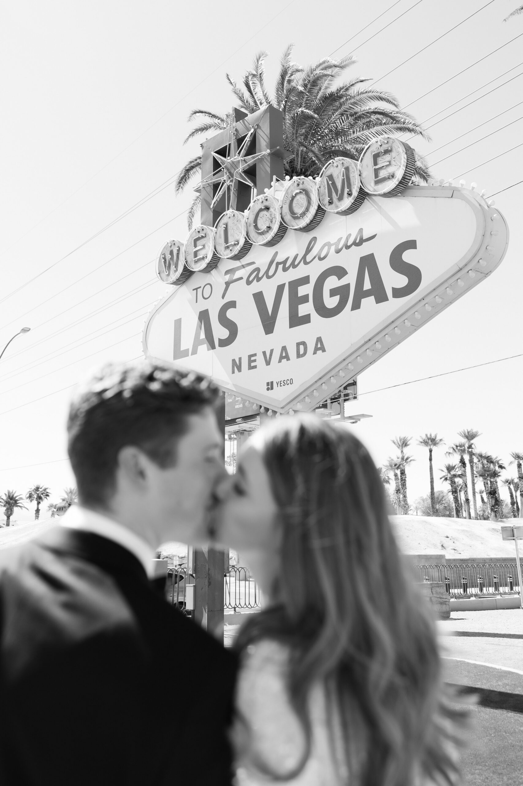 Bride and groom kissing in front of the Welcome to Las Vegas sign