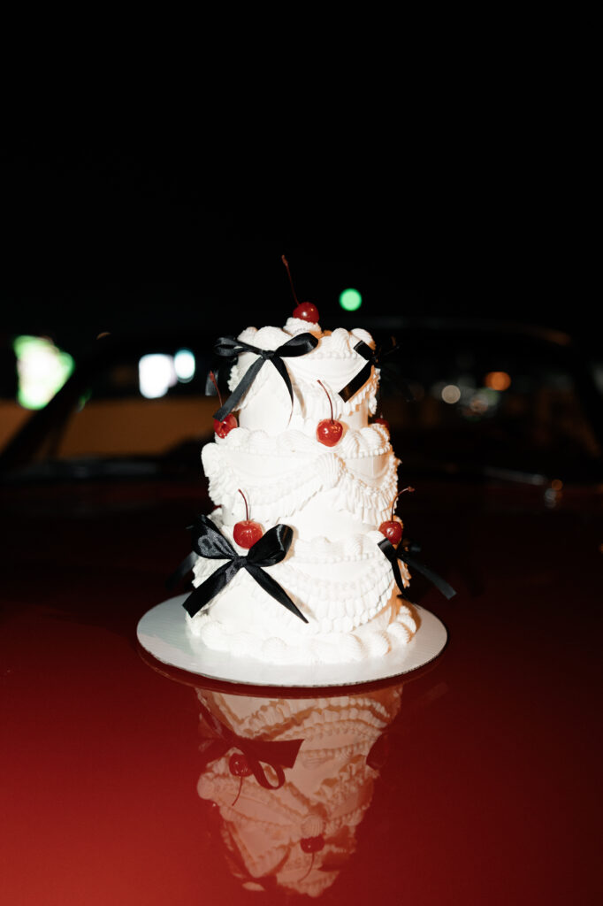 A three tiered vintage inspired Las Vegas elopement cake with cherries and black bow ties