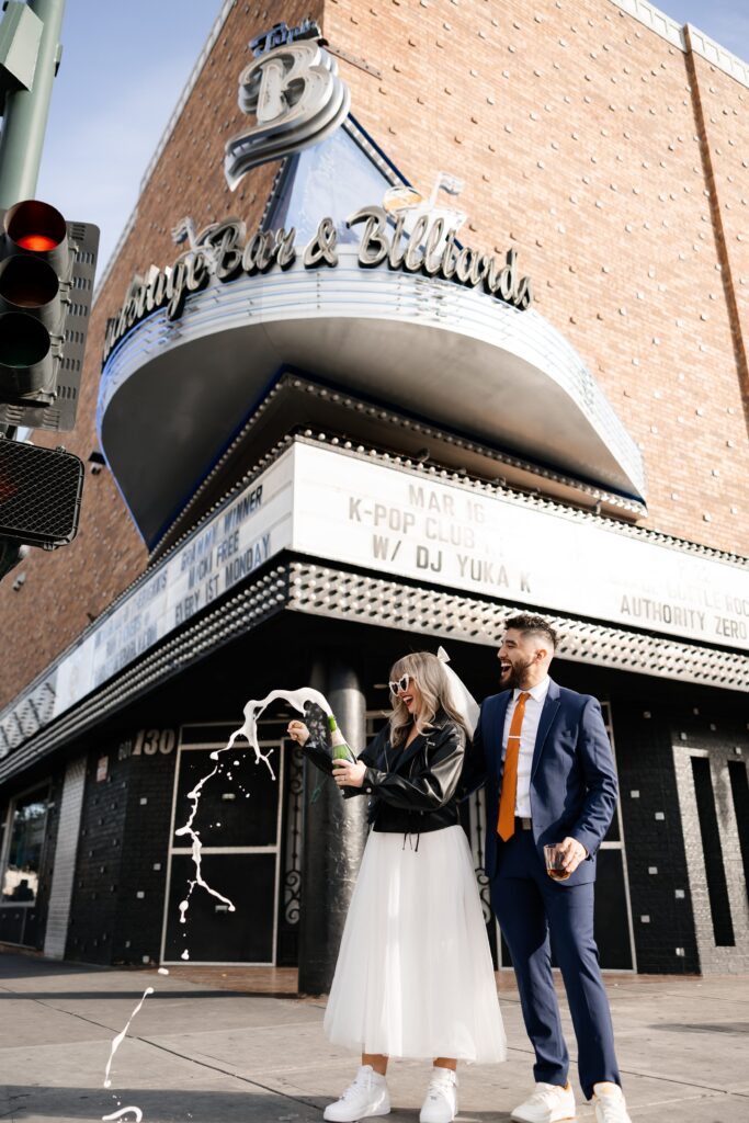 Bride and groom popping champagne during their Las Vegas elopement