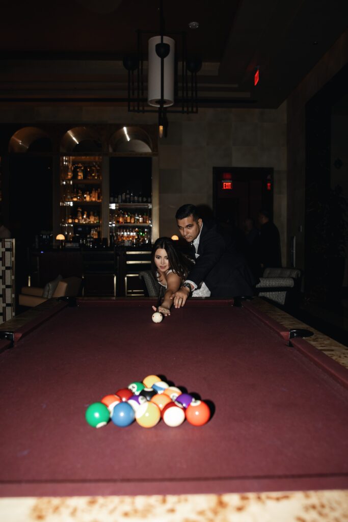 Bride and groom playing pool together