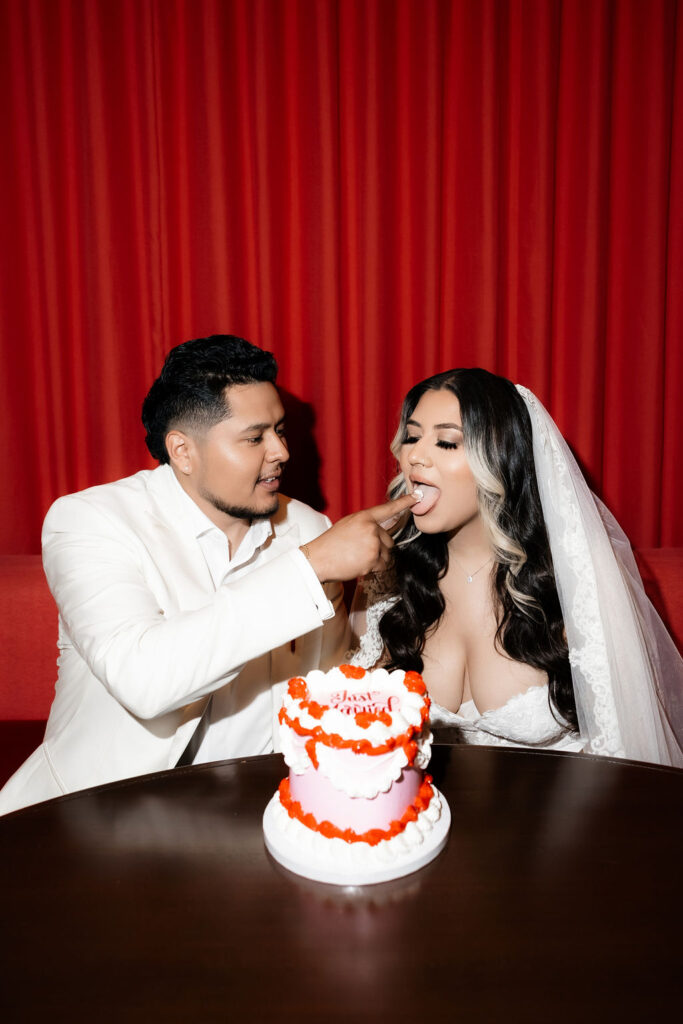 Groom feeding the bride cake off of his finger