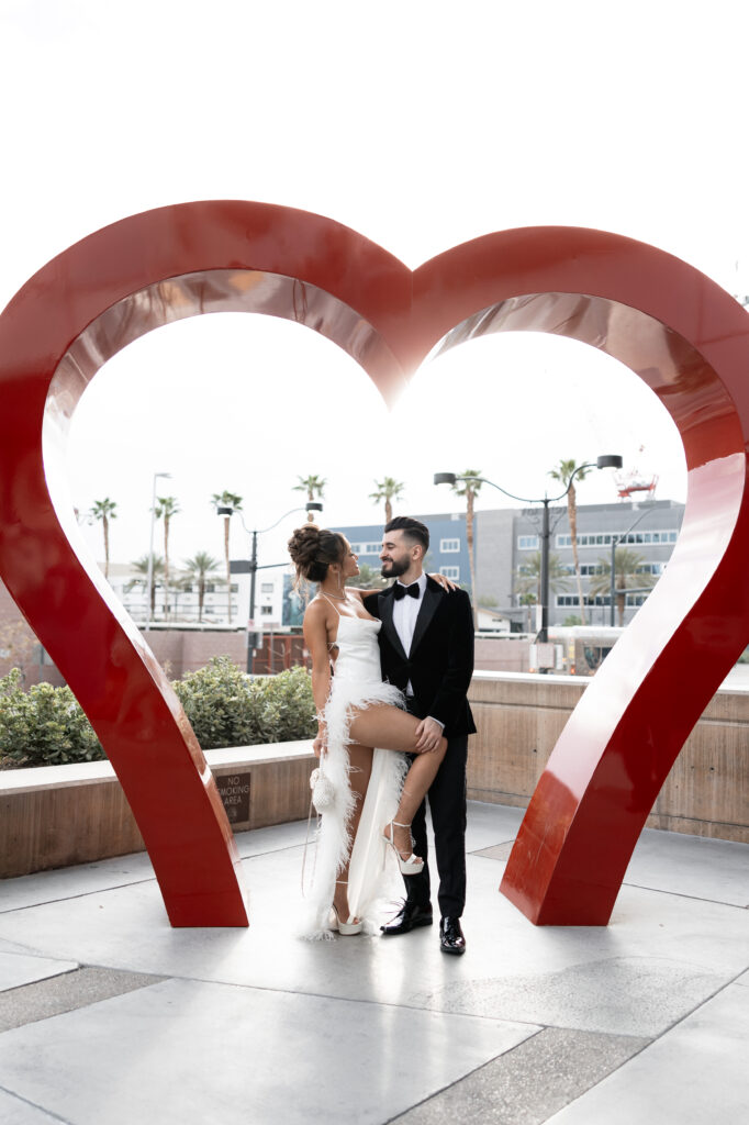 Bride and groom posing inside the heart sculpture in Las Vegas for their elopement portraits