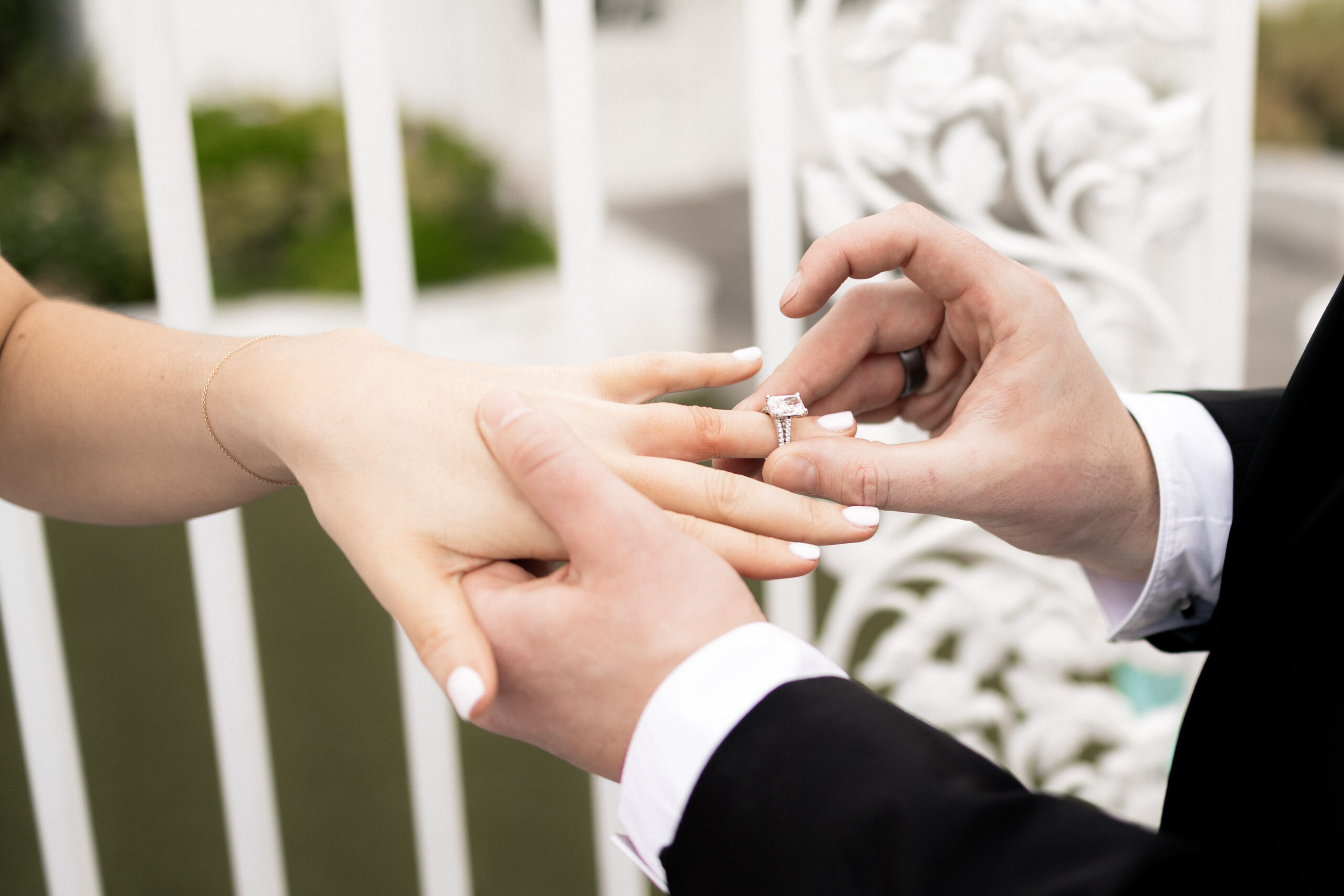 Groom putting brides wedding ring onto her finger