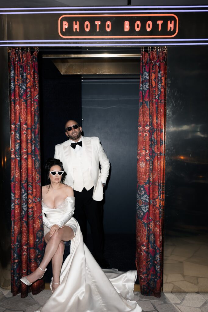 Flash editorial elopement photo of a bride and groom posing in the photo booth at Virgin Hotel in Las Vegas